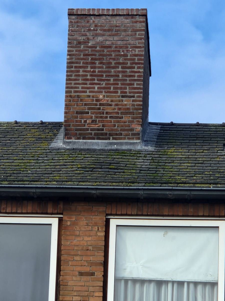 Schoorsteen met dakpannen en dakrand van een woning
