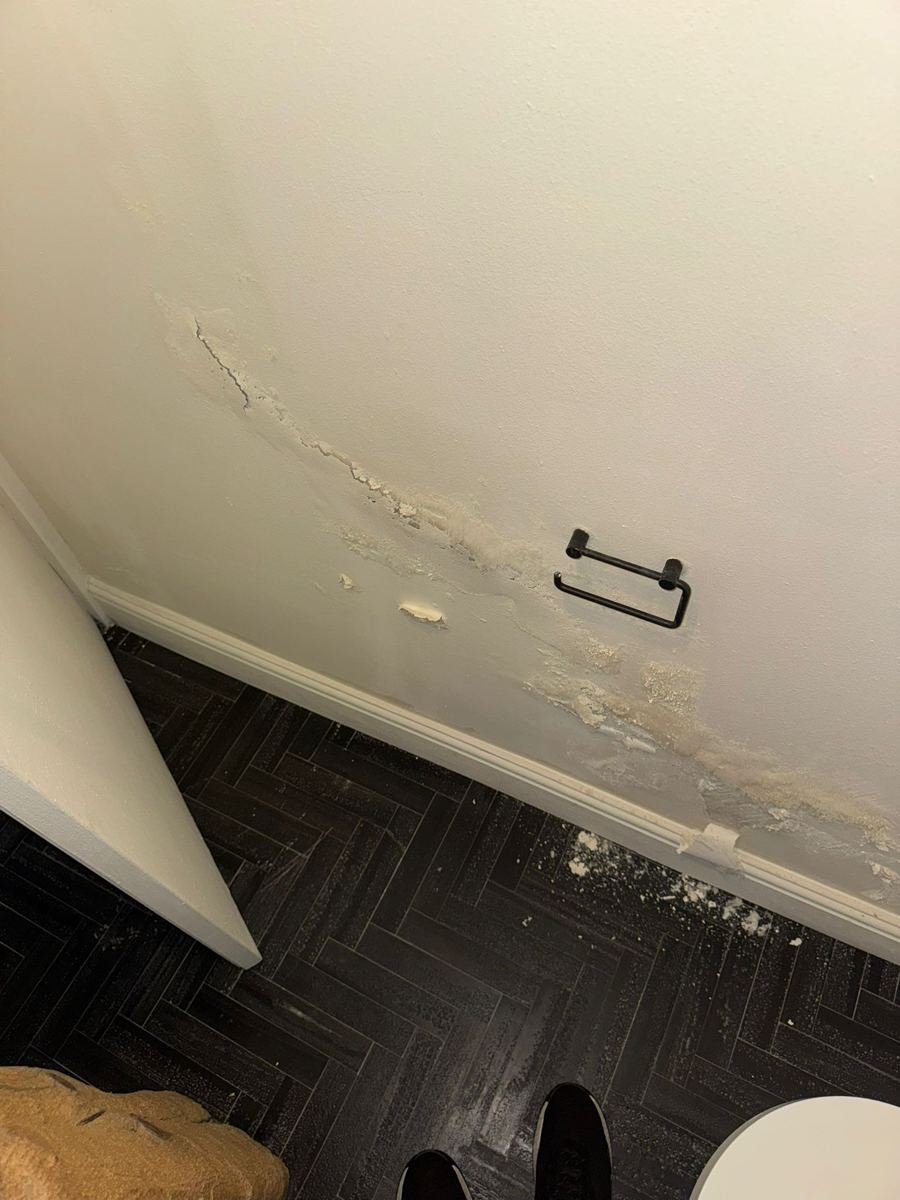 Vochtschade aan de onderkant van een wand bij een badkamervloer