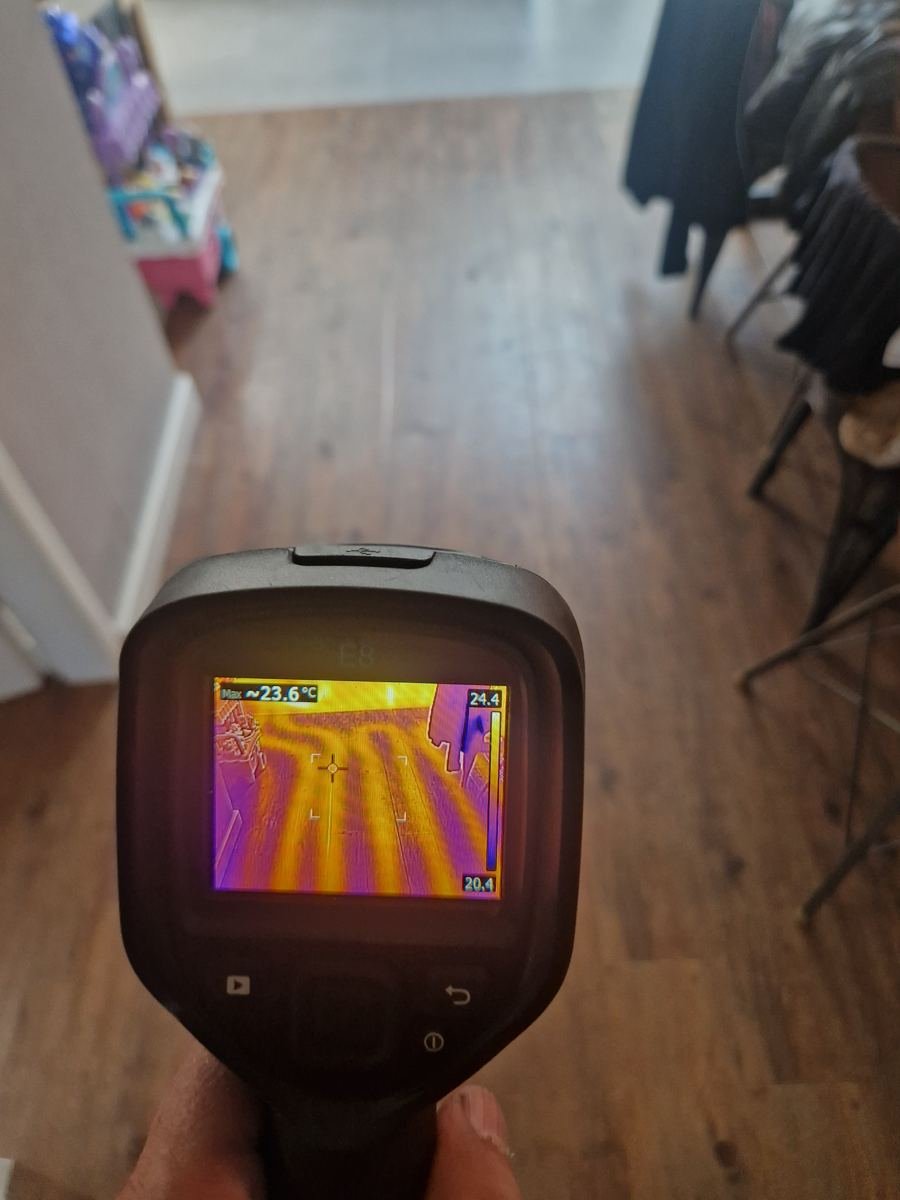 Warmtebeeldcamera toont het verloop van vloerverwarmingsleidingen onder een houten vloer